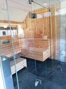 a sauna with wooden walls and a glass shower stall at Ferienhaus Asterbach in Gosau