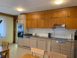 uma cozinha com armários de madeira e electrodomésticos de aço inoxidável em Apartment Natali em Schnaittenbach