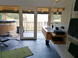 ein Badezimmer mit einem Waschbecken und einer Glasschiebetür in der Unterkunft Ferienhaus Asterbach in Gosau