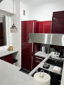 cocina con armarios rojos y encimera en Nice : Superbe Studio Chaleureux et fonctionnel, en Niza