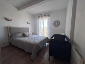 een slaapkamer met een bed en een raam bij Logement entier : Maison in Saleilles +9 foto's