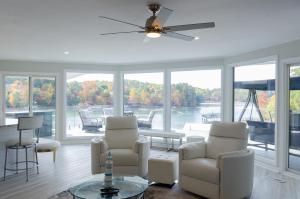 a living room with chairs and a table and windows at Lakeside Haven in Gainesville