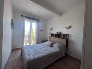 een witte slaapkamer met een bed en een raam bij Logement entier : Maison in Saleilles