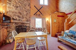 uma sala de jantar com mesa e cadeiras e uma parede de pedra em Iron River Vacation Rental - Walk to Ski Brule! em Iron River