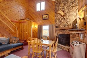 a dining room with a table and a fireplace in a cabin at Iron River Vacation Rental with Ski Slope Views! in Iron River