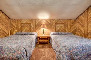 Iron RiverにあるIron River Vacation Rental with Ski Slope Views!のベッド2台、テーブル(ランプ付)が備わる客室です。