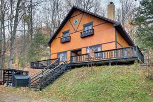 a large orange house on top of a hill at Iron River Vacation Rental with Ski Slope Views! in Iron River