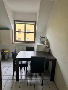 una mesa y sillas en una cocina con ventana en Schöne Wohnung in einer ruhiger Umgebung, en Machern