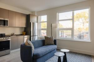 a living room with a blue couch and a kitchen at Placemakr NoMa in Washington