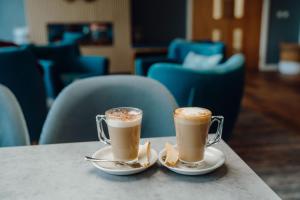 two cups of coffee sitting on a table at The Dunes in Tenby