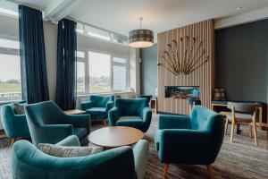 a waiting room with blue chairs and a fireplace at The Dunes in Tenby