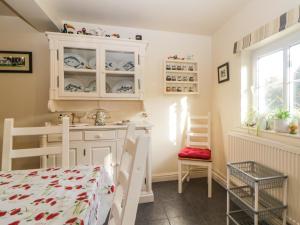 a kitchen with a white cabinet and a table at The Miller's Cottage in Okehampton