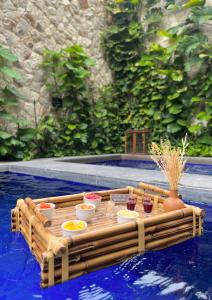 uma mesa de madeira numa piscina com comida em Pauli Boutique Hotel em Fortaleza