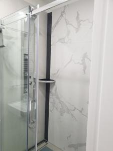 a shower with a glass door in a bathroom at Apart LILI in Polanica-Zdrój