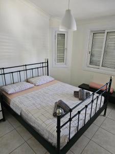 - une chambre avec un lit avec un cadre noir et 2 fenêtres dans l'établissement Trudy's home, à Nicosie