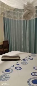 a bed with a white and blue bedspread with a napkin at PagersHome Suites - Classic Nyarutarama in Kigali