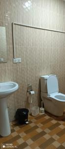 La salle de bains est pourvue de toilettes et d'un lavabo. dans l'établissement PagersHome Suites - Classic Nyarutarama, à Kigali