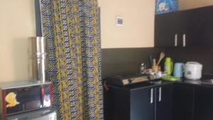 a kitchen with a curtain in the corner of a room at PagersHome Suites - Classic Nyarutarama in Kigali