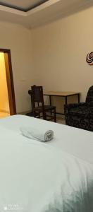 a room with a bed and two chairs and a table at PagersHome Suites - Classic Nyarutarama in Kigali