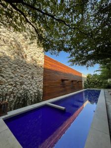 a swimming pool in front of a stone wall at Pauli Boutique Hotel in Fortaleza