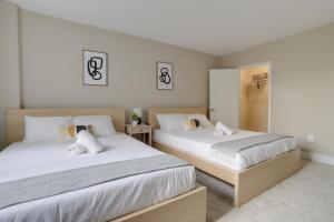 a bedroom with two beds with white sheets at Elegant Condo for Business Travelers @Crystal City in Arlington