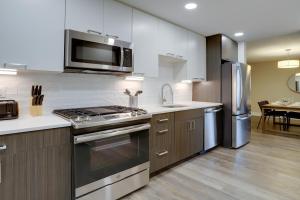 uma cozinha com um fogão e um micro-ondas em Elegant Condo for Business Travelers @Crystal City em Arlington