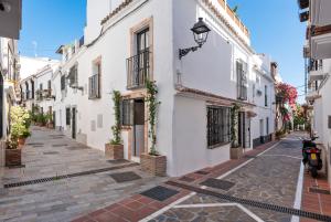 una calle en un casco antiguo con edificios blancos en Casa Aduar 22 2b MarbellaOldTown, en Marbella