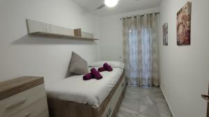 Un dormitorio con una cama con almohadas moradas. en Apartamentos Málaga junto al Centro en Málaga