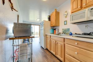 a kitchen with wooden cabinets and a refrigerator at Sanderling Sea Cottages, Unit 13 in Waldport