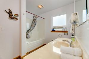 a white bathroom with a sink and a tub at Sanderling Sea Cottages, Unit 13 in Waldport +19 photos