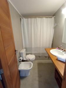 a bathroom with a toilet and a sink at Chacras del mar in Mar Azul +9 photos