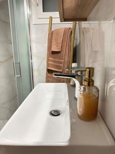 a white bathroom sink with a soap dispenser on it at A modern apartment by the sea in Xylokastro