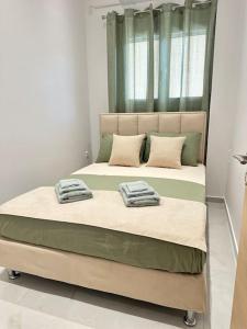 a bed with two pillows on it in a room at A modern apartment by the sea in Xylokastro