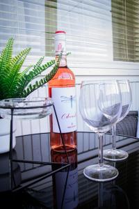 a bottle of wine and two wine glasses on a table at Villa Blue Arany Apartman in Szekszárd