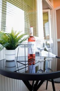 una mesa con copas de vino y una botella en ella en Villa Blue Arany Apartman en Szekszárd