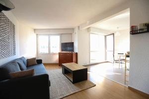sala de estar con sofá y mesa en Special Loft : 40 m² de confort, en Cergy