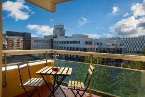 balcón con mesa, sillas y vistas a la ciudad en Special Loft : 40 m² de confort, en Cergy
