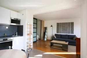 a living room with a blue couch and a table at Special Loft : 40 m² de confort in Cergy