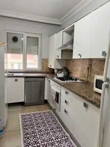 a kitchen with white cabinets and a rug on the floor at Gulev in Istanbul