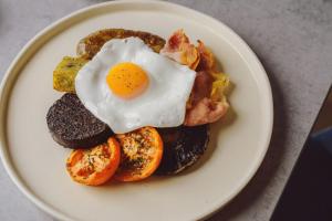 a plate of breakfast food with an egg on top at The Dunes in Tenby