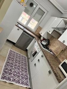 a kitchen with white cabinets and a black and white rug at Gulev in Istanbul