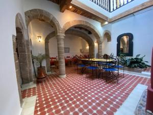 a hall with a table and chairs in a building at Riad Darbask in Essaouira