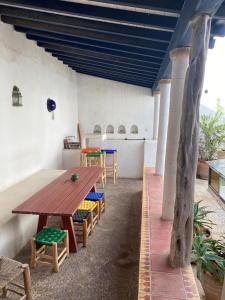a patio with a wooden table and chairs in a room at Riad Darbask in Essaouira