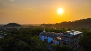 un edificio con la puesta de sol en el fondo en Hotel Posada Stella Maris, en Puerto Barrios