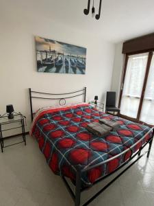 莫利亞諾威尼托的住宿－House of music near venice，一间卧室配有一张带红色和蓝色毯子的床