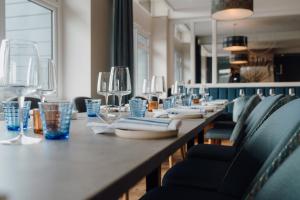 a long table with chairs and plates and wine glasses at The Dunes in Tenby
