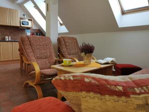 uma sala de estar com cadeiras e uma mesa com um livro em Penzion Mia em Dolní Moravice