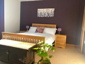 a bedroom with a bed and a bench and a painting at Belle Vue, 5 bedroom house in Cockermouth
