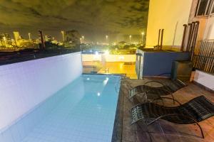 a swimming pool on top of a building at night at Hotel Golden Park Rio de Janeiro Aeroporto By Nacional Inn in Rio de Janeiro