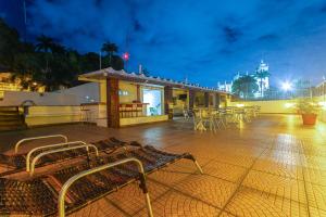a building with tables and chairs on a patio at night at Hotel Golden Park Rio de Janeiro Aeroporto By Nacional Inn in Rio de Janeiro